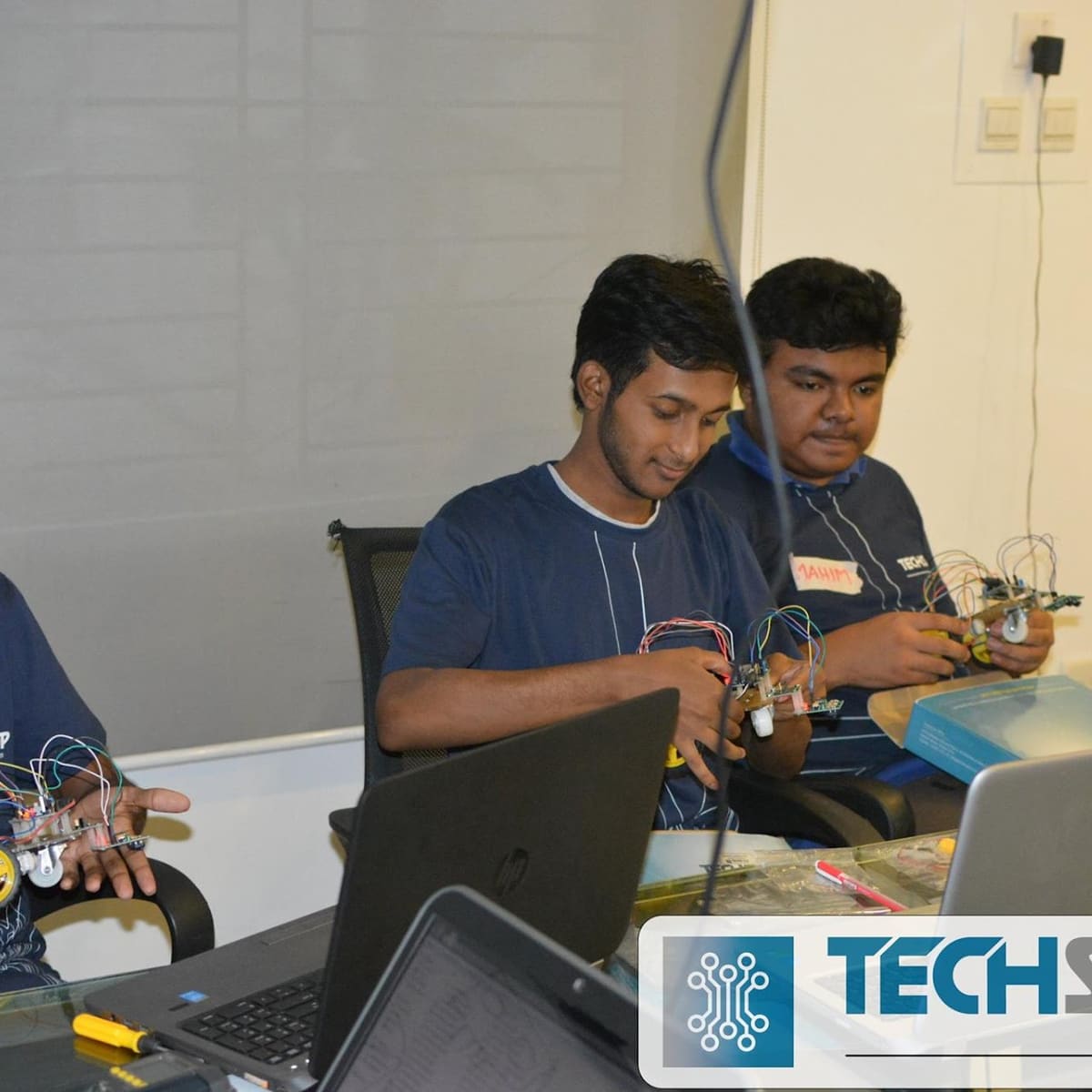 Building a robot at a workbench with a laptop