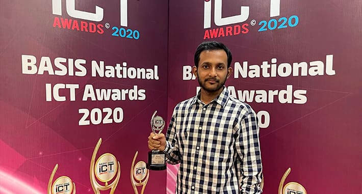 Holding the BASIS National ICT Award trophy in front of the event backdrop