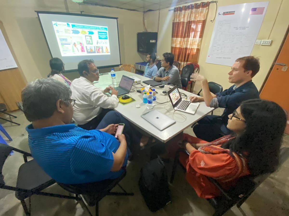 Meeting around a table with laptops at the Tdh office in Teknaf